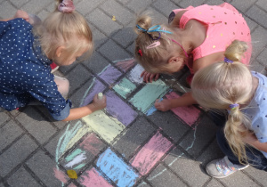 Dzieci rysują na chodniku kropki